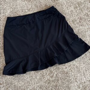 Tail black golf skirt with ruffled bottom.